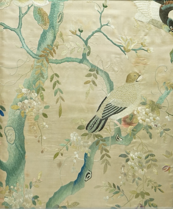 A pair of framed 19th century Chinese silk embroideries of exotic birds amongst entwined flowering branches, embroidered on a beige silk back ground, possibly cut from a larger embroidery. 47cm x 57cm., Condition - one f